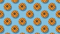 A pattern of yellow glazed donuts on a blue background