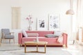 Patterned armchair and pink couch in feminist apartment interior