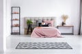 Patterned black and white rug on the floor of contemporary bedroom interior with comfortable bed Royalty Free Stock Photo