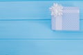 Patterned blue gift box on wood with copyspace. Royalty Free Stock Photo