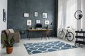 Patterned carpet in bright workspace interior with bicycle next Royalty Free Stock Photo