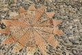 Patterned floor with sea pebbles red bricks and metal gears Royalty Free Stock Photo