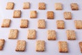 patterned mosaic of cookies with sesame seeds on a white background