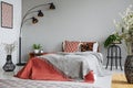 Patterned pillow and grey blanket on king size bed with dark orange duvet in luxury bedroom interior in elegant apartment Royalty Free Stock Photo