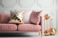 Patterned pillow on a velvet pink sofa and copper gold accessories in a feminine living room interior with empty white wall. Royalty Free Stock Photo