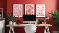 Patterned poster on table with computer monitor in red home office interior with plants Royalty Free Stock Photo