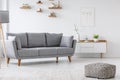 Patterned pouf and grey couch in minimal living room interior wi Royalty Free Stock Photo
