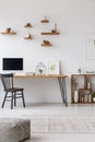 Patterned pouf in minimal workspace interior with black chair at