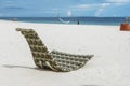A patterned wicker chaise lounge chair right by the beachfront. At Dumaluan Beach, Panglao Island, Bohol, Philippines