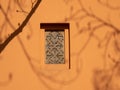 Patterned window on a brown wall. Royalty Free Stock Photo