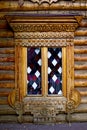 Patterned Windows in the old Russian log hut. Well-developed wood structure of the log. Royalty Free Stock Photo