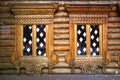 Patterned Windows in the old Russian log hut. Well-developed wood structure of the log. Royalty Free Stock Photo