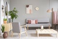 Patterned wooden armchair next to table in grey flat interior wi