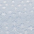 Patterns of intricate snowflakes embossed on a textured white surface. Each Royalty Free Stock Photo