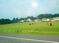 Pature field with hay bales and houses