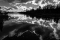 Lake and forest with dramatic clouds reflected in black and whit Royalty Free Stock Photo