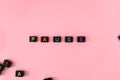 Pause button concept. Black beads on pink background making word Royalty Free Stock Photo