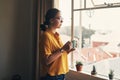 A pause puts it into perspective. a young woman having coffee and looking thoughtful while working from home.