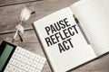 pause, reflect, act concept words on notepad and calculator and wooden background