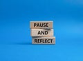 Pause and Reflect symbol. Concept words Pause and Reflect on wooden blocks. Beautiful blue background. Business and Pause and Royalty Free Stock Photo