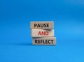 Pause and Reflect symbol. Concept words Pause and Reflect on wooden blocks. Beautiful blue background. Business and Pause and Royalty Free Stock Photo