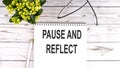 PAUSE AND REFLECT text concept write on notebook on wooden background Royalty Free Stock Photo