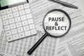 PAUSE AND REFLECT word on magnifying glass with calculator and documents Royalty Free Stock Photo