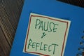 Pause and Reflect write on sticky notes isolated on Wooden Table Royalty Free Stock Photo