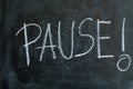 Pause written in chalk on a blackboard