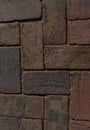 Paved aged bricks pavement of dark red-brown stones, close-up top view above of cobblestones for background or texture