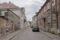 Paved with cobblestone street of the old town with an spectacular ancient abandoned wooden two-story house Royalty Free Stock Photo