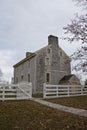 Paved pathway and open gate leads to old style Shaker home.