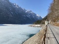 Paved road by the alpine resevoir lake KlÃÂ¶ntalersee Kloentalersee or Klontaler lake and in the KlÃÂ¶ntal alpine valley / Kloental