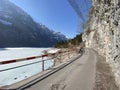 Paved road by the alpine resevoir lake KlÃÂ¶ntalersee Kloentalersee or Klontaler lake and in the KlÃÂ¶ntal alpine valley / Kloental