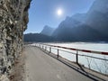 Paved road by the alpine resevoir lake KlÃÂ¶ntalersee Kloentalersee or Klontaler lake and in the KlÃÂ¶ntal alpine valley / Kloental