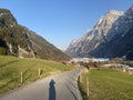 Paved road by the alpine resevoir lake KlÃÂ¶ntalersee Kloentalersee or Klontaler lake and in the KlÃÂ¶ntal alpine valley / Kloental