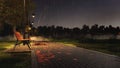 Empty bench on park walkway at rainy autumn night Royalty Free Stock Photo