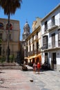 Pavement cafes along a city centre street with the Cathedral bell tower to the rear, Malaga, Spain.