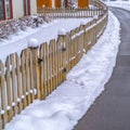 Pavement in front of snowy lawn and fence of home