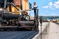 Pavement machine laying fresh asphalt or bitumen