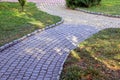 Pavement paths of stone tiles among the green grass in the park Royalty Free Stock Photo