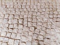 Pavement paved with uneven natural stones. Between crushed cobblestones there are small pebbles, earth, sand, grass. Square in the