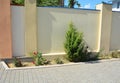 Paver backyard with a narrow small low maintanance flowerbed with juniper and roses next to the brick fence