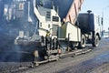 Paver machine laying asphalt, fed by a dump truck Royalty Free Stock Photo