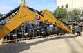 Caterpillar excavator boom in front of a large assortment of digger buckets by the official dealership.