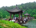 A pavilion over the lake with tourists walking through