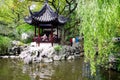 A pavilion for people to enjoy the cool, belongs to the Chinese garden art, there are rockeries and willow trees next to the