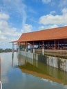 a pavilion with a pool filled with water around it with a bright blue sky as a background