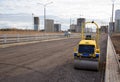 Paving roller machine during road work. Mini road roller at construction site for paving works. Screeding the sand for road Royalty Free Stock Photo