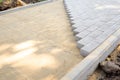 Paving slabs or paving stones are laid out on the sand between the curbstone. The process of building a footpath Royalty Free Stock Photo